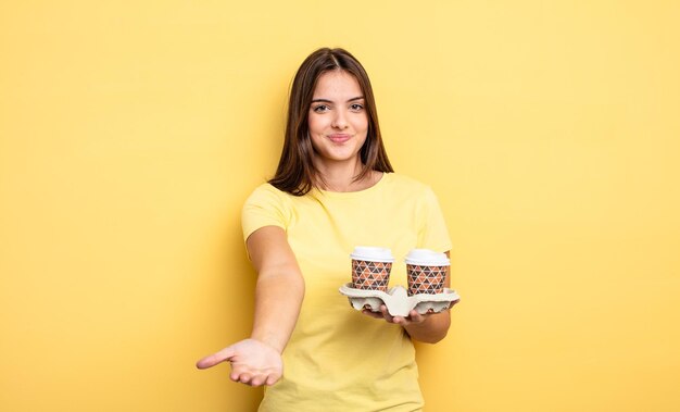 Linda mujer sonriendo felizmente con amistad y ofreciendo y mostrando un concepto. concepto de café para llevar