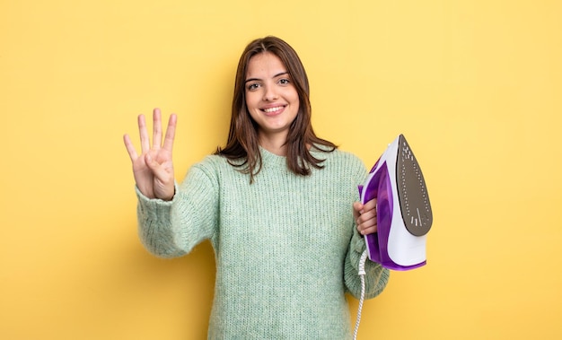 Linda mujer sonriendo y luciendo amigable, mostrando el número cuatro. concepto de ropa de hierro