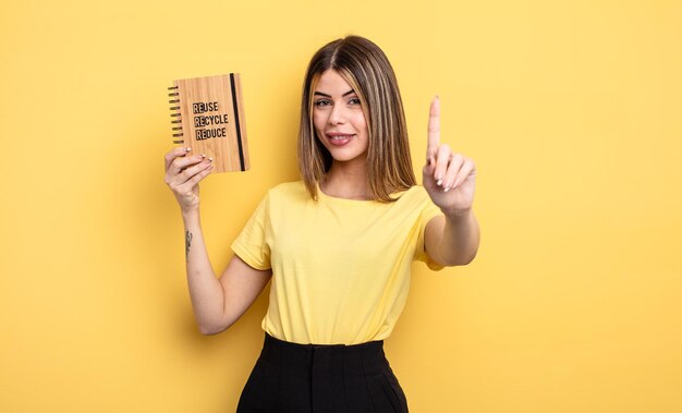 Linda mujer sonriendo con orgullo y confianza haciendo el número uno. concepto de reciclaje