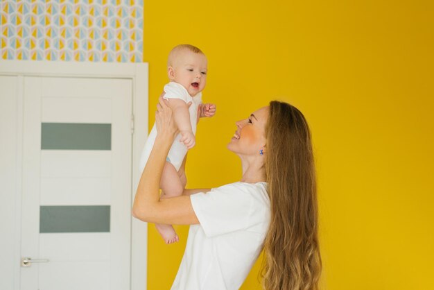 Linda mujer sosteniendo a un bebé recién nacido en sus brazos