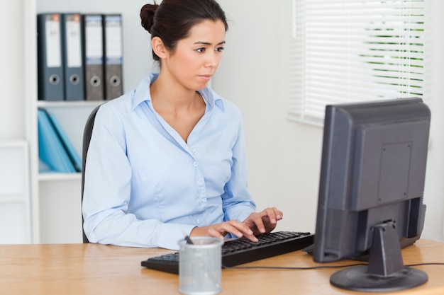 Linda mujer trabajando en una computadora mientras está sentado