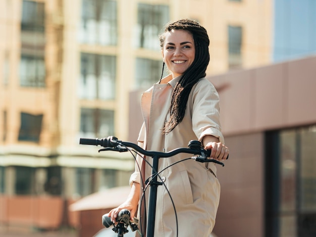 Foto linda mulher adulta posando com bicicleta ecológica