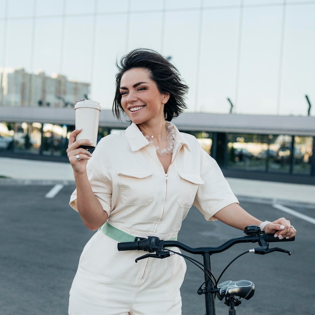 Foto linda mulher adulta posando com bicicleta ecológica