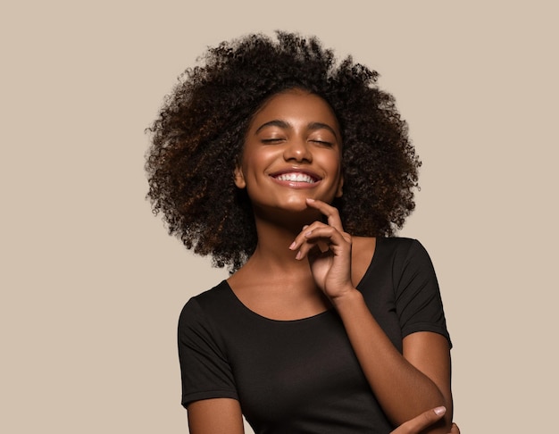 Foto linda mulher africana camiseta preta retrato corte de cabelo afro tocando seu rosto cor de fundo marrom