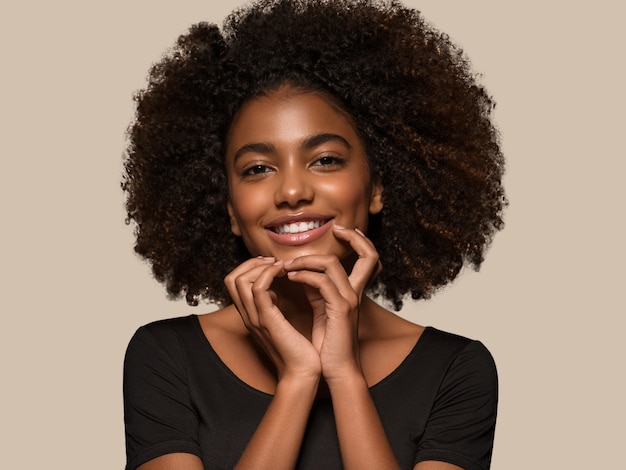 Linda mulher africana camiseta preta retrato corte de cabelo afro tocando seu rosto Cor de fundo marrom