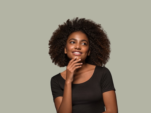 Linda mulher africana camiseta preta retrato corte de cabelo afro tocando seu rosto cor de fundo verde