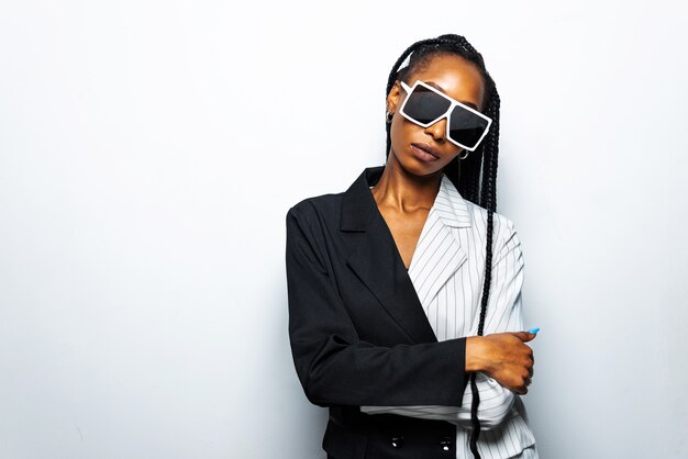 Foto linda mulher afro-americana com penteado afro de tranças e roupas elegantes - retrato de uma jovem negra em estúdio