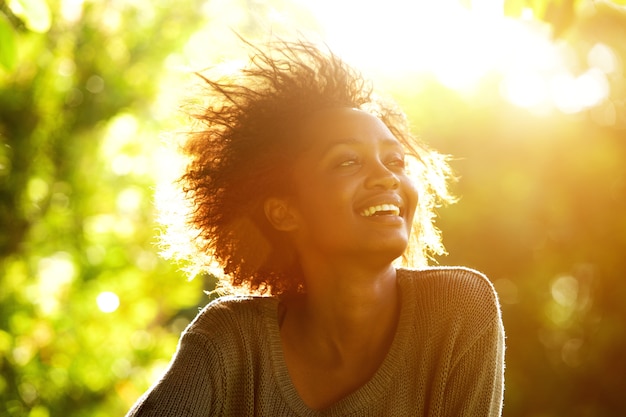 Linda mulher afro-americana sorrindo com pôr do sol