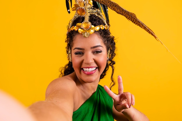 Linda mulher afro brasileira com cabeça de dançarina para carnaval fazendo uma selfie