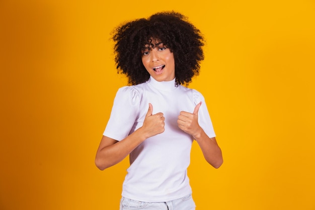 Linda mulher afro com o polegar para cima. mulher fazendo sinal de ok.