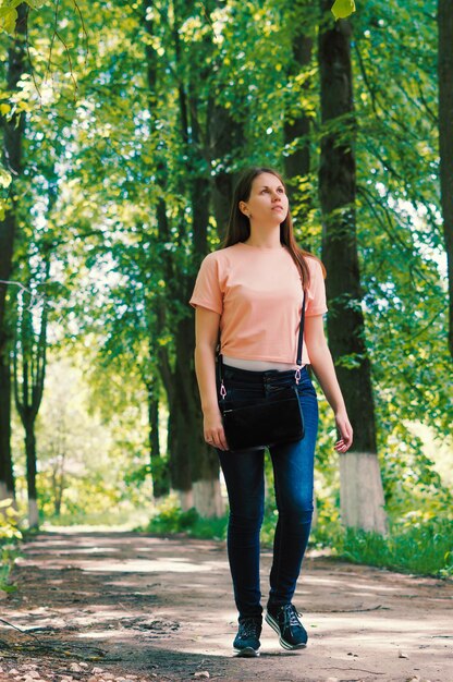linda mulher andando por uma floresta em um lindo dia de verão