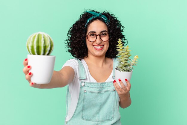 linda mulher árabe com cacto em vaso decorativo