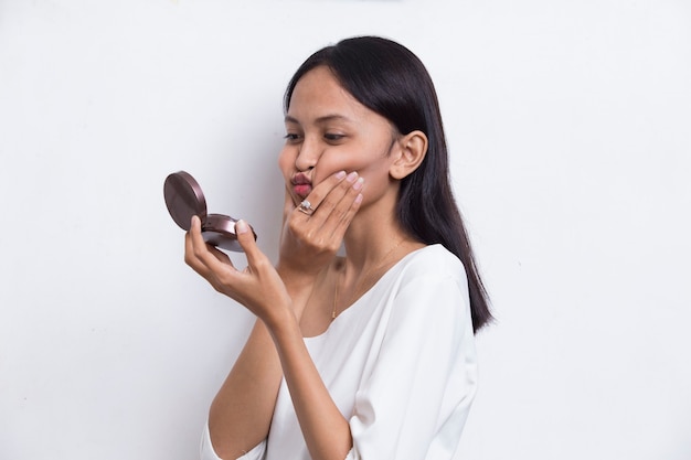 linda mulher asiática aplicando pó na maquiagem do cosmético isolado no fundo branco