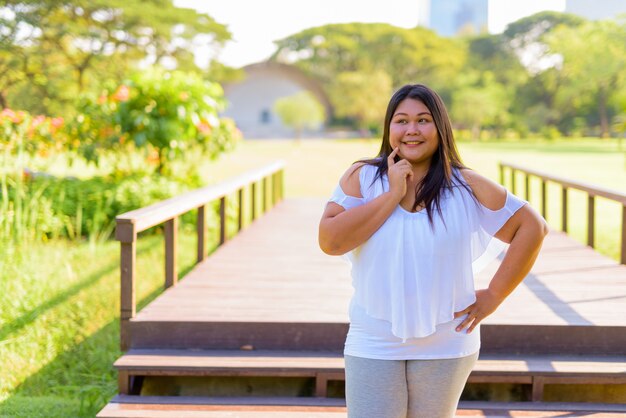 Linda mulher asiática com excesso de peso relaxando no parque