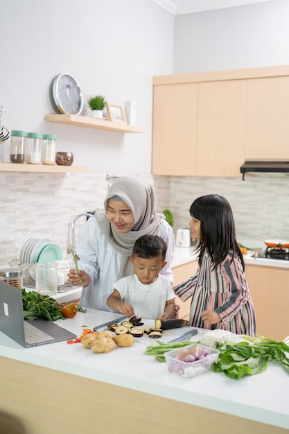 Linda mulher asiática com filha e filho preparando o jantar