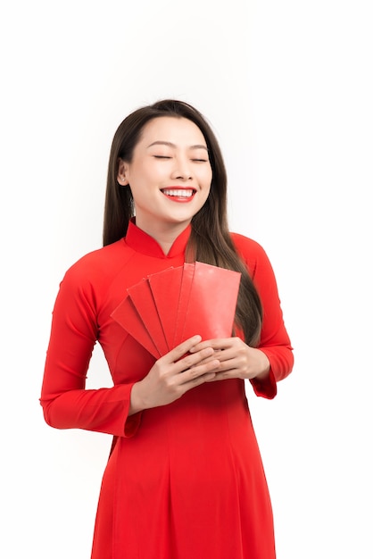 Linda mulher asiática com vestido longo vietnamita tradicional segurando um envelope vermelho e sorrindo