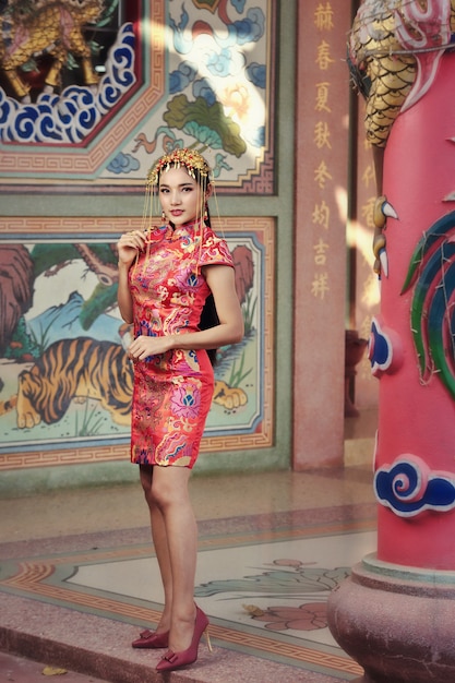 Linda mulher asiática em vestido chinês tradicional com gesto de parabéns no ano novo chinês