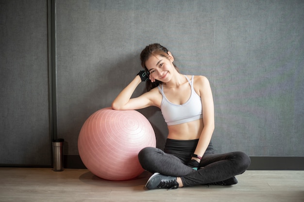 Linda mulher asiática está fazendo exercício no ginásio