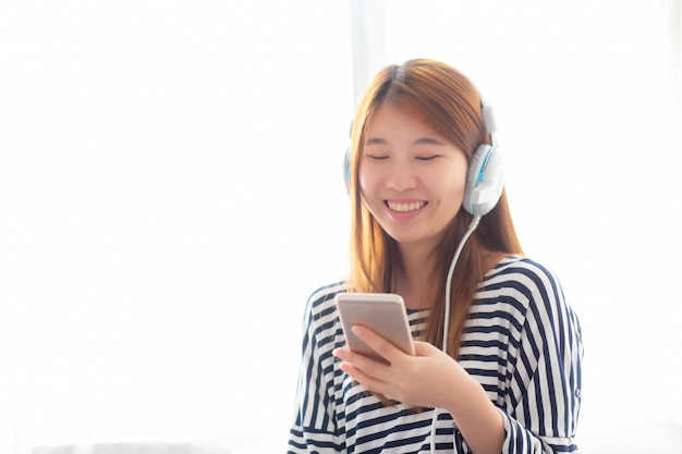Linda mulher asiática gosta de ouvir música com fone de ouvido