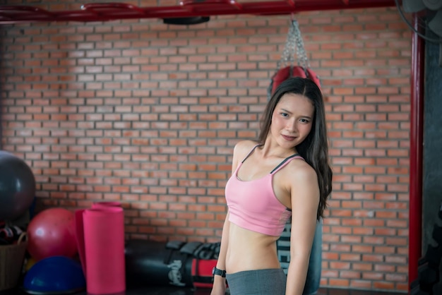Linda mulher asiática joga fitness na academiaA menina da Tailândia tem um corpo esbeltoTempo para o exercícioAs pessoas adoram o corpo esticando o corpo antes do treino