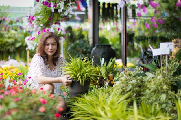 Linda mulher asiática, selecionando flores na loja de flores, estilo de vida da dona de casa moderna.