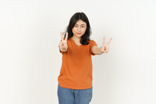 Linda mulher asiática usando camiseta laranja mostrando sinal de paz ou vitória isolado no branco