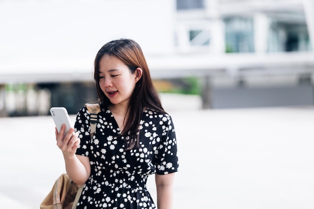 Linda mulher asiática usando telefone inteligente no conceito de estilo de vida da cidade