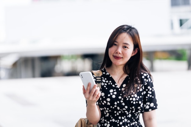 Linda mulher asiática usando telefone inteligente no conceito de estilo de vida da cidade