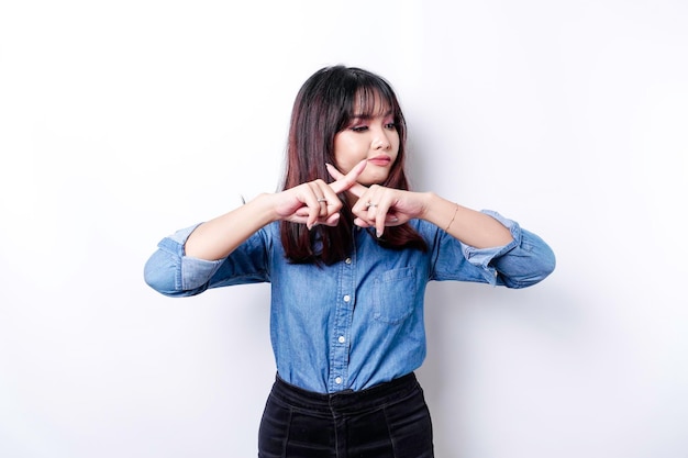 Linda mulher asiática vestindo camisa azul com gesto de mão posar rejeição ou proibição com espaço de cópia