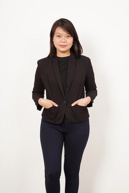 Linda mulher asiática vestindo um terno preto em pé com a mão no bolso, isolado no fundo branco