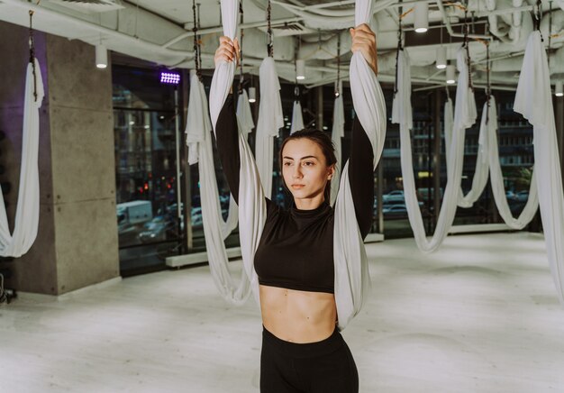 Linda mulher atlética treinando em uma academia fazendo exercícios de alongamento antes do treino