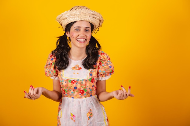 Linda mulher brasileira com roupas de festa junina convidando com as mãos