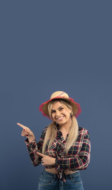 Linda mulher brasileira com roupas de festa junina em fundo azul