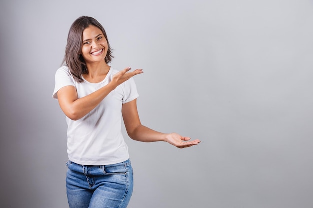 Linda mulher brasileira denim e branco apresentando produto ou propaganda marketing de publicidade