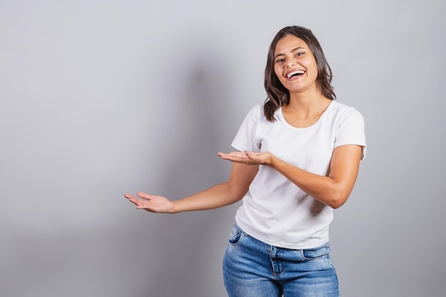 Linda mulher brasileira denim e branco apresentando produto ou propaganda marketing de publicidade