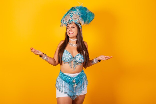 Linda mulher brasileira em roupas de carnaval azuis e brancas com coroa de penas de braços abertos