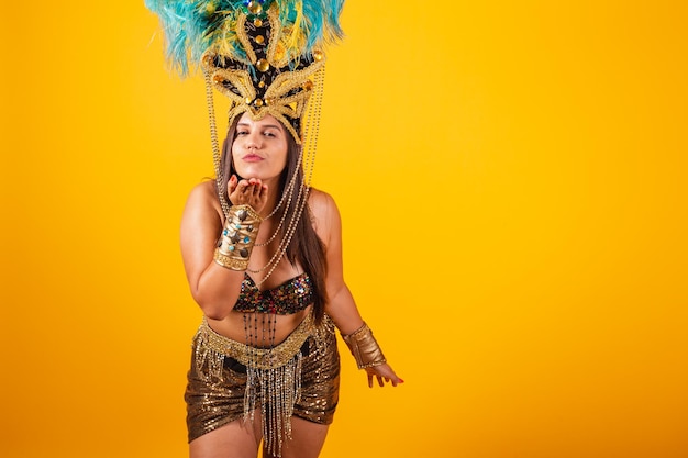 Linda mulher brasileira em roupas douradas de carnaval usando coroa de penas de dançarina de carnaval enviando