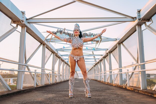 Linda mulher brasileira vestindo fantasia colorida de carnaval e sorrindo durante o desfile de carnaval na cidade.