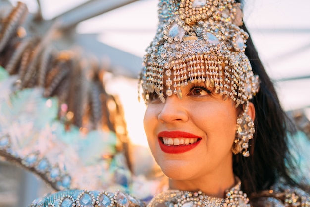 Linda mulher brasileira vestindo fantasia colorida de carnaval e sorrindo durante o desfile de carnaval na cidade.