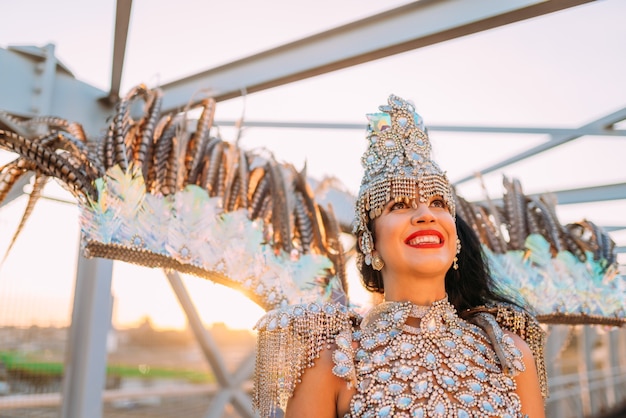 Linda mulher brasileira vestindo fantasia colorida de carnaval e sorrindo durante o desfile de carnaval na cidade.