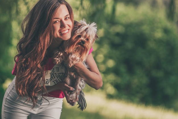 Linda mulher brincar com cachorro no parque