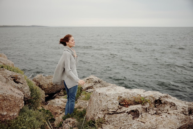 Linda mulher caminhada de liberdade no conceito de relaxamento da costa de pedra