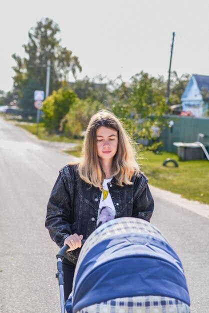 Linda mulher carregando um bebê em um carrinho