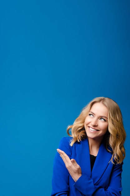 Linda mulher caucasiana com cabelo ondulado claro e jaqueta azul gosta disso isolado em fundo azul