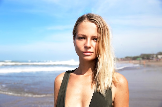 Linda mulher caucasiana de biquíni verde na praia tropical. Retrato de jovem no oceano