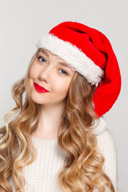 Linda mulher com chapéu de Papai Noel sorrindo.