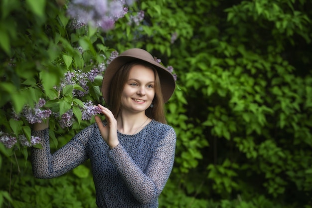 Linda mulher com coroa de flores lilás Menina em uma coroa de flores lilás na primavera Guirlanda lilás