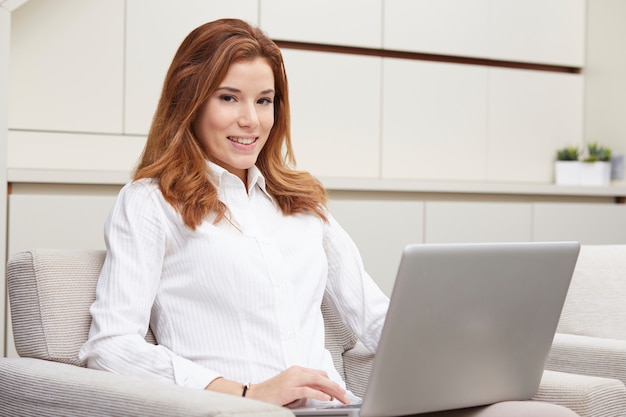 Linda mulher com laptop no sofá