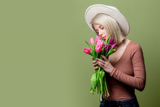 Linda mulher com um chapéu com buquê de tulipas