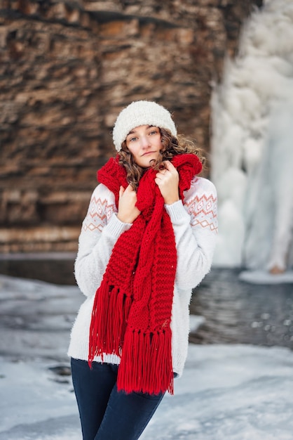 Linda mulher com um chapéu e um lenço comprido posando no frio